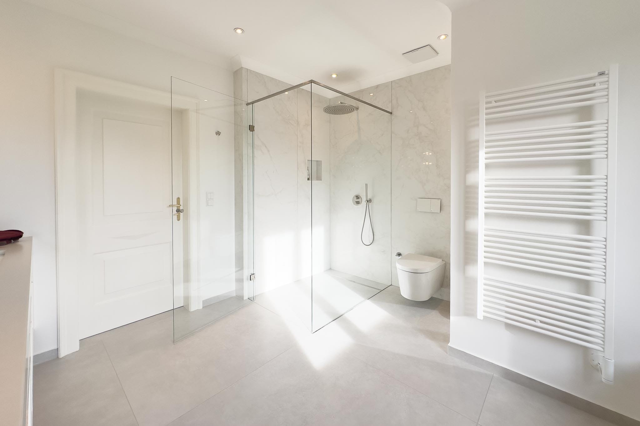 Luxury bathroom with limestone-look porcelain stoneware floor tiles and marble-look wall tiles