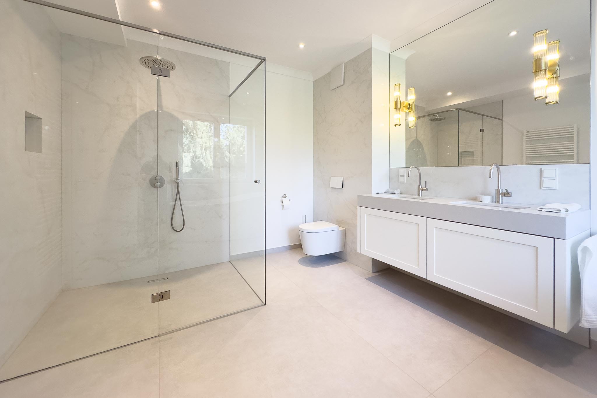 Luxury bathroom with limestone-look porcelain stoneware floor tiles and marble-look wall tiles