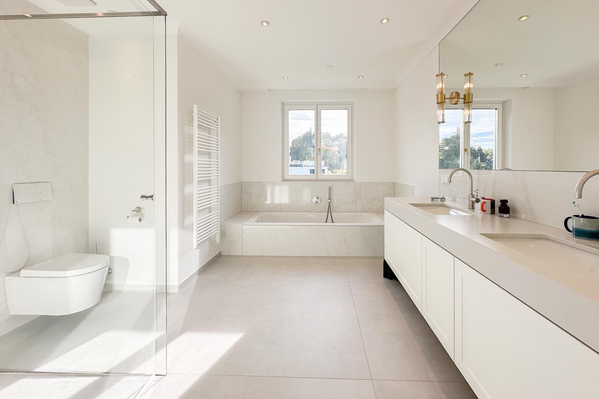 Luxury bathroom with limestone-look porcelain stoneware floor tiles and marble-look wall tiles
