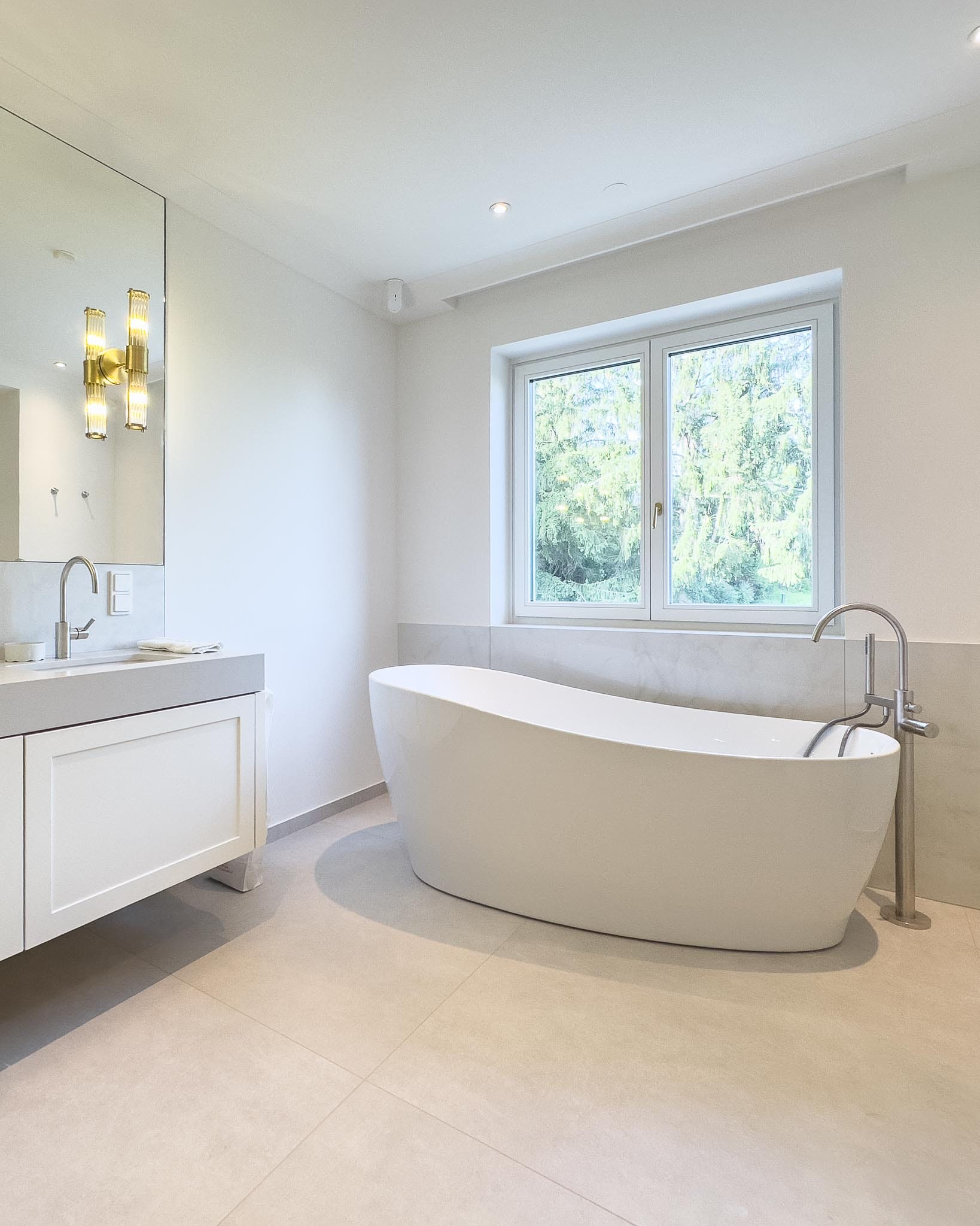 Luxury bathroom with limestone-look porcelain stoneware floor tiles and marble-look wall tiles